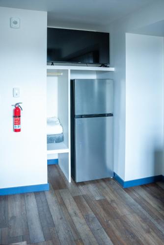 an empty room with a kitchen with a refrigerator at Vasanoja Suite 102, Hyland Hotel in Palmer