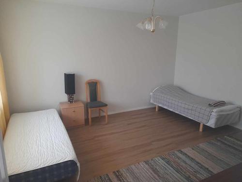 1 dormitorio con 1 cama, TV y silla en Liberty apartment Ilmarisentie20, en Kuopio