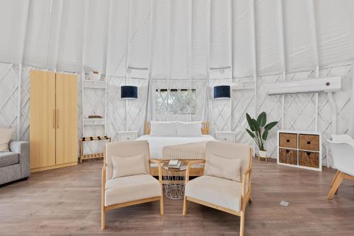 a bedroom with a bed and two chairs and a table at The Cedars Ranch in Wimberley