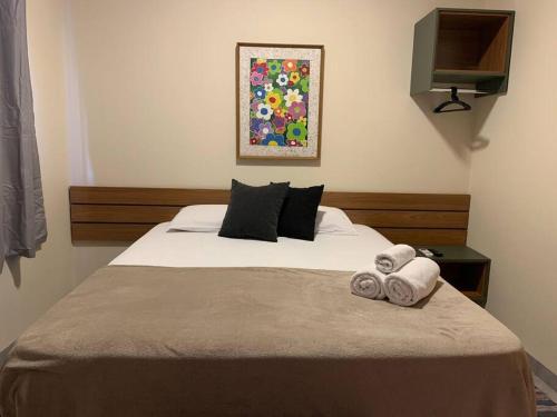 een slaapkamer met een bed met handdoeken erop bij Studio Standard l AO LADO SHOPPING in Três Lagoas