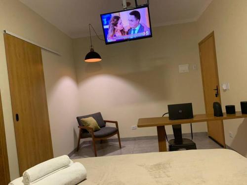 a bedroom with a bed and a tv on the wall at Studio Standard l AO LADO SHOPPING in Três Lagoas