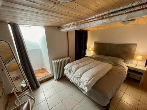 une chambre avec un grand lit et une fenêtre dans l'établissement Centre de Luchon grand Appartement rénové, à Luchon