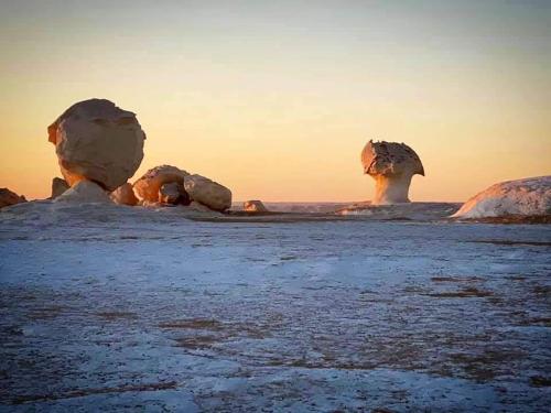 an image of two large rock formations in the ocean at oasis panorama in Bawiti