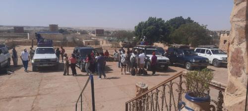 a group of people standing in a parking lot at oasis panorama in Bawiti