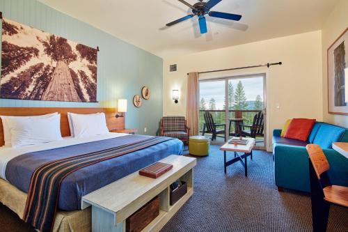 a bedroom with a bed and a couch and a table at Rush Creek Lodge at Yosemite in Groveland