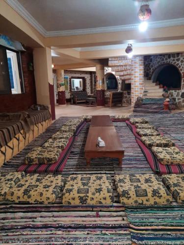 a room with a table and chairs and a large rug at oasis panorama in Bawiti