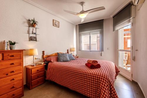 ロス・アルカサレスにあるCasa Jansiver - 450m de la playa, céntrica pero tranquilaのベッドとドレッサーと窓のある寝室