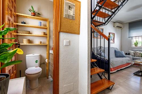 a bathroom with a toilet and a spiral staircase at Casa Jansiver - 450m de la playa, céntrica pero tranquila in Los Alcázares