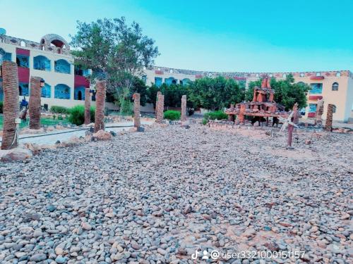 un edificio con un montón de piedras delante de él en oasis panorama en Mandīshah