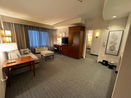 a hotel room with a desk and a living room at Courtyard Long Beach Airport in Long Beach