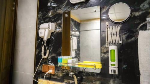 a bathroom with a sink with a phone and a mirror at Jiger Palace Hotel in Erbil