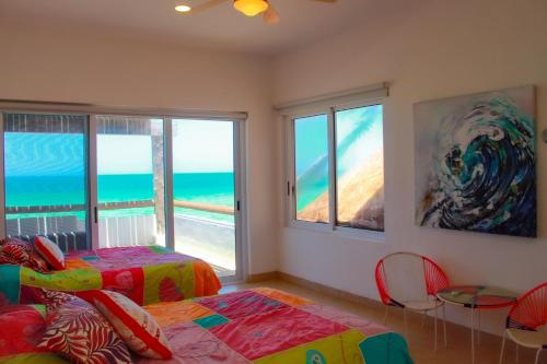 Nisiros Spacious Beachfront home في تشيكشولوب: غرفة نوم مع سرير وإطلالة على المحيط