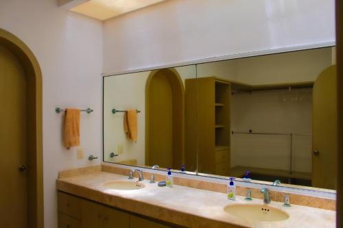 baño con 2 lavabos y espejo grande en Nisiros Spacious Beachfront home, en Chicxulub