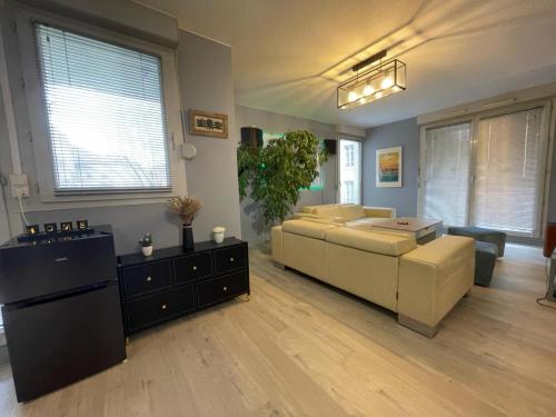a living room with a couch and a table at Appartement très proche centre LYON, 4 personnes in Caluire-et-Cuire