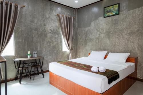 um quarto com uma cama grande e uma mesa em Buengngarm Resort 