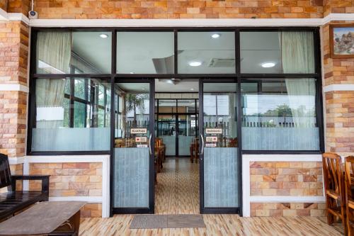 een restaurant met glazen deuren en een bakstenen muur bij Buengngarm Resort in Ban Sok Pho