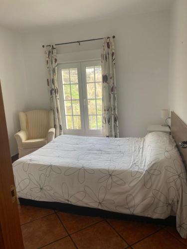 a bedroom with a bed and a window at CASA EL RÍO in Trevélez