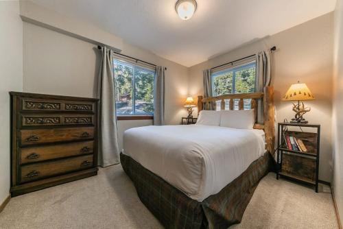 a bedroom with a large bed and two windows at Carnelian Bay 4BD Near Beach & Slopes in Carnelian Bay