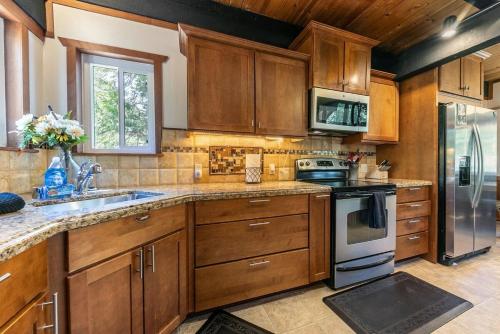 eine Küche mit Holzschränken, Spüle und Herd in der Unterkunft Carnelian Bay 4BD Near Beach & Slopes in Carnelian Bay