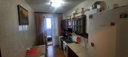 a kitchen with a stove and a counter top at Затишна, домашня 43м в тихому зеленому місці Поруч Центральний парк Університет in Irpin'