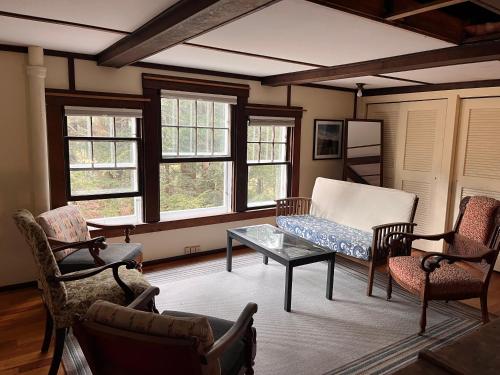 uma sala de estar com um sofá, cadeiras e janelas em Storybook Lake Front Villa with Private Beach! em Winchester