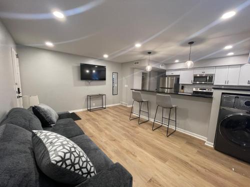 a living room with a couch and a kitchen at Cathedral 6-Walk to UNMC in Omaha