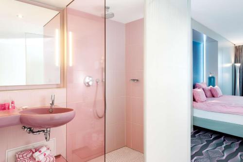 een badkamer met een wastafel en een douche bij nhow Berlin in Berlijn