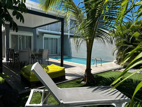 a patio with a table and a chair next to a pool at La villa Romah - 3 ch piscine - Baie Orientale in Orient Bay