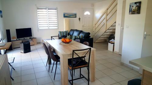 een keuken en een woonkamer met een tafel en stoelen bij maison de vacances Lège-Cap-Ferret in Lège-Cap-Ferret