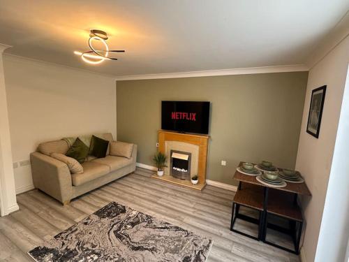 sala de estar con sofá y chimenea en Mmc serviced accommodation 2, en Leigh