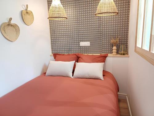 une chambre avec un lit avec deux oreillers dans l'établissement L'escapade - 1 lit et 1 couchage d'appoint - Proche centre ville, à Amiens