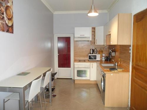une cuisine avec des armoires blanches et une table dans l'établissement Appartement 2 pieces centre ville, à Salon-de-Provence