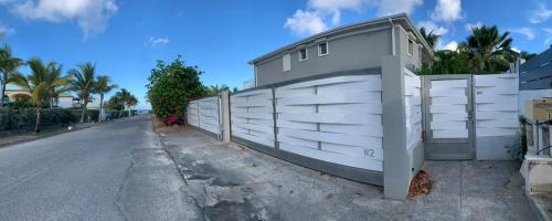 a white fence on the side of a road at La villa Romah - 3 ch piscine - Baie Orientale in Orient Bay