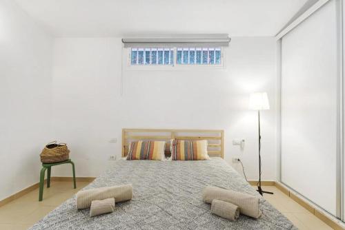 a bedroom with a bed with two pillows and a window at Child-friendly, 3-bedroom apartment with garden near the Aqualand in Adeje