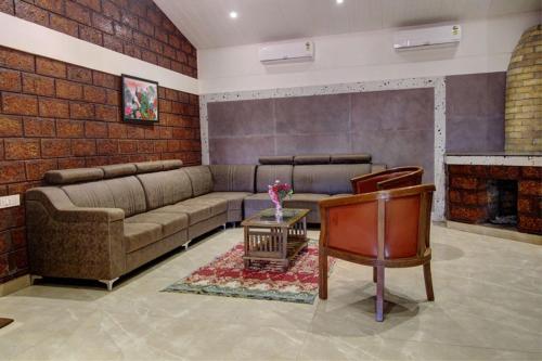 ein Wohnzimmer mit einem Sofa und einem Kamin in der Unterkunft Forest County Resort in Mahabaleshwar