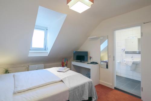 een slaapkamer met een bed en een badkamer met een wastafel bij Hotel Saarlouis am kleinen Markt in Saarlouis