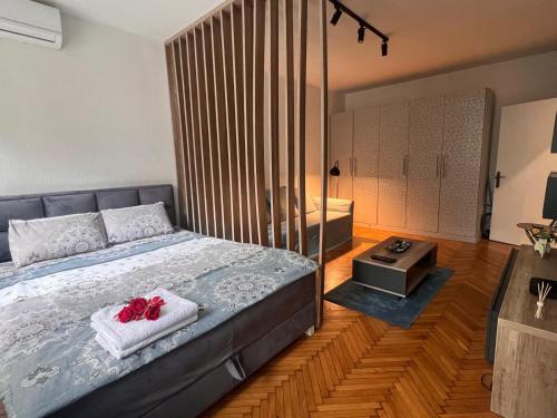 ein Schlafzimmer mit einem Bett mit zwei roten Rosen darauf in der Unterkunft Cozy Nest Apartment in Belgrad