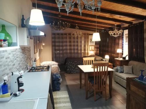 Casa della Quercia في سان جيوفاني لا بونتا: مطبخ وغرفة معيشة مع طاولة وأريكة