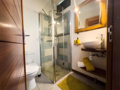 uma casa de banho com um chuveiro, um WC e um lavatório. em Bungalow le Balisier em Pointe-Noire