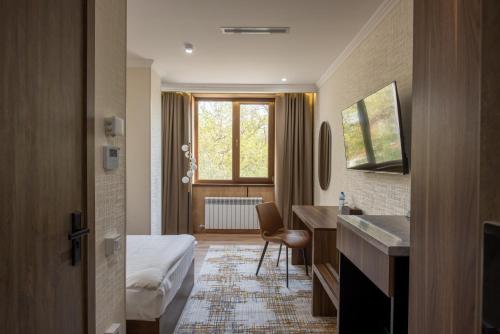 タシュケントにあるSilk Road Tashkentのベッドと洗面台があるホテルの部屋