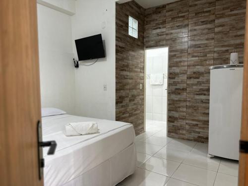 ein Schlafzimmer mit einem Bett und einem TV sowie ein Badezimmer in der Unterkunft Studio Executivo no Centro de Santarém - WIFI e Central de Ar in Santarém