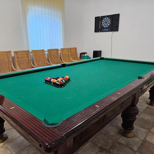 a pool table with a tray of cue balls on it at Club Biliard in Bicaz