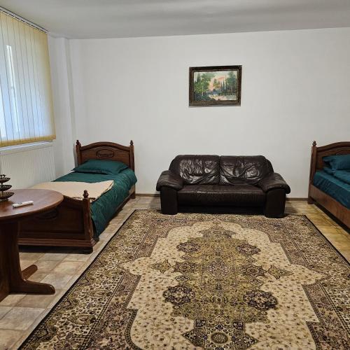 uma sala de estar com um sofá e uma cama em Club Biliard em Bicaz