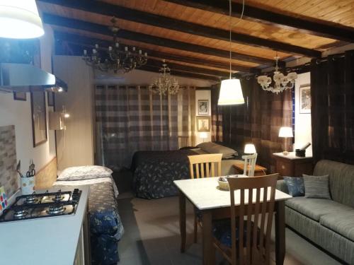 a kitchen and living room with a bed and a table at Casa della Quercia in San Giovanni la Punta