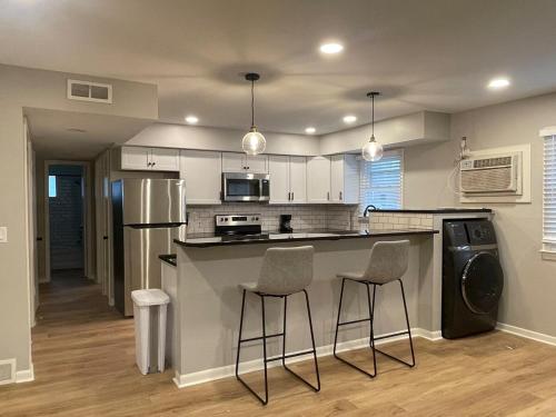 a kitchen with a counter and two bar stools at Cathedral 7-New & Modern near UNMC in Omaha