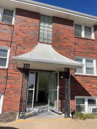 a brick building with a white awning on it at Cathedral 7-New & Modern near UNMC in Omaha