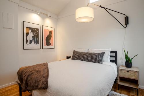 1 dormitorio con 1 cama blanca y 2 cuadros en la pared en 1BR and Loft, Close to Creekside Gondola by Harmony Whistler Vacations, en Whistler