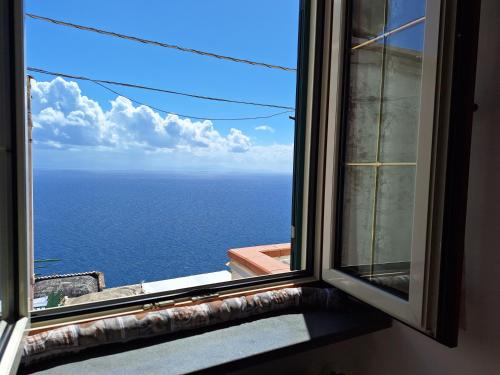 an open window with a view of the ocean at villa lucia in Conca dei Marini