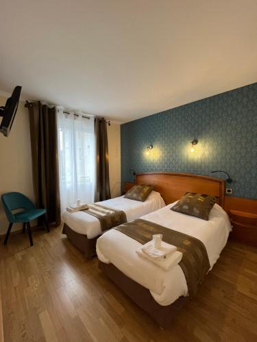 a hotel room with two beds and a chair at Hotel Le Lion d'Or in Saint-Geniez-dʼOlt