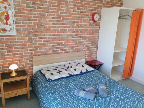 a bed in a room with a brick wall at Proche Paris,Cosy appartement, 3 bedrooms in Saint-Ouen